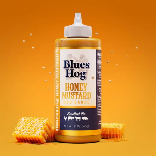 Blues Hog Honey Mustard BBQ sauce bottle centered on an orange background with honeycomb chunks.