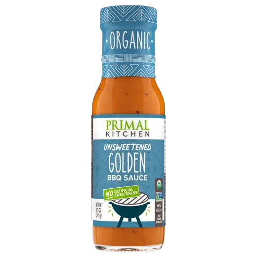 A bottle of Primal Kitchen unsweetened golden BBQ sauce against a black background.
