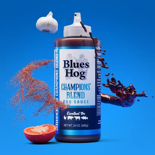 A single bottle of Blues Hog Champions' Blend BBQ sauce featuring floating garlic and tomato slices.