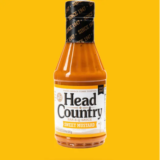 A bottle of Head Country Sweet Mustard barbecue sauce on a yellow background.