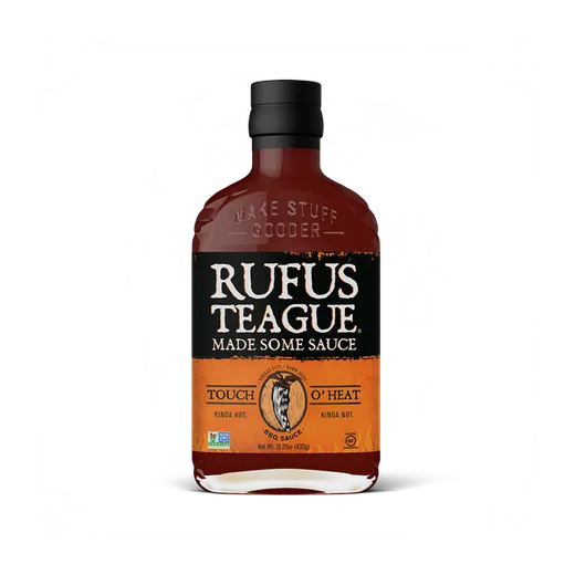 Straight-on shot of an orange-labeled Rufus Teague barbecue sauce bottle.