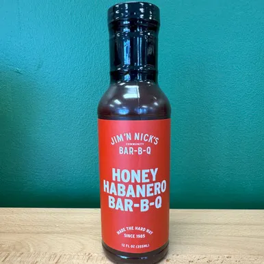 A bottle of Jim 'N Nick's Honey Habanero BBQ Sauce displayed upright.