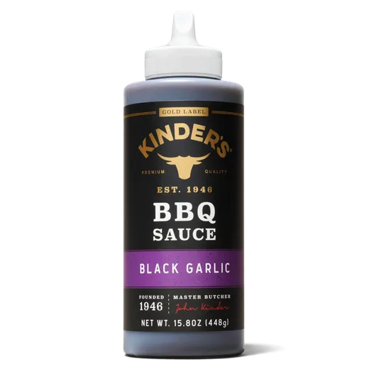 A bottle of Kinder's Black Garlic BBQ sauce against a black background.