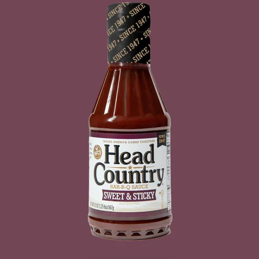 A standard bottle of Head Country Sweet & Sticky BBQ Sauce shown against a plain color background.